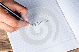 Man erase word `PROBLEM` on book